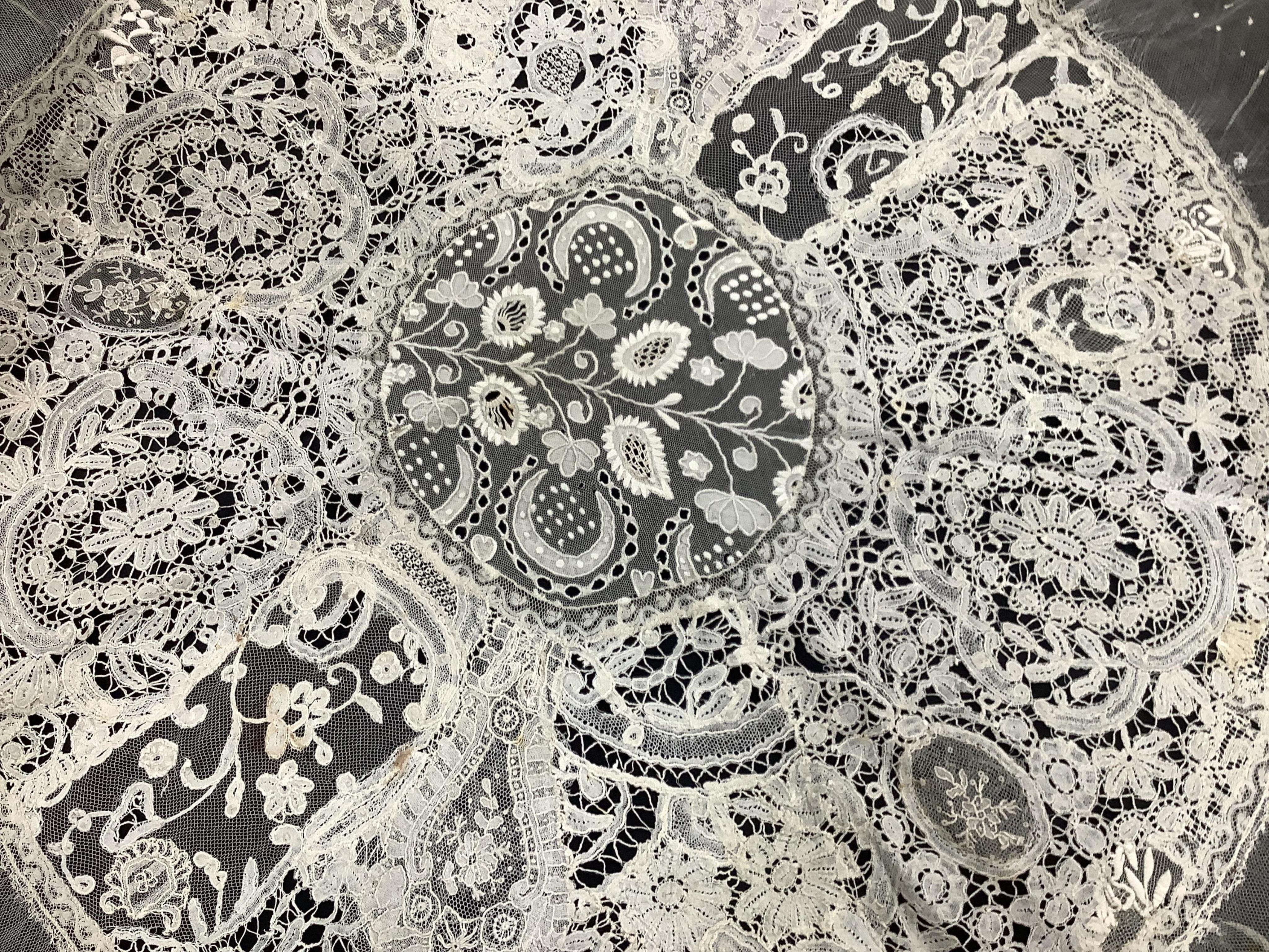 A late 19th / early 20th century circular Normandy lace table cover, with five similar smaller lace mats: all patch worked together from hand bobbin and hand needle laces, possibly part of a wedding trousseau. larger clo